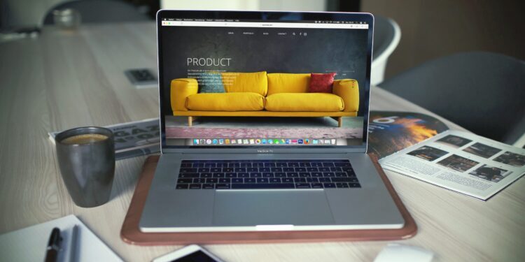 Laptop computer sitting on a desk with iPhone and mouse.